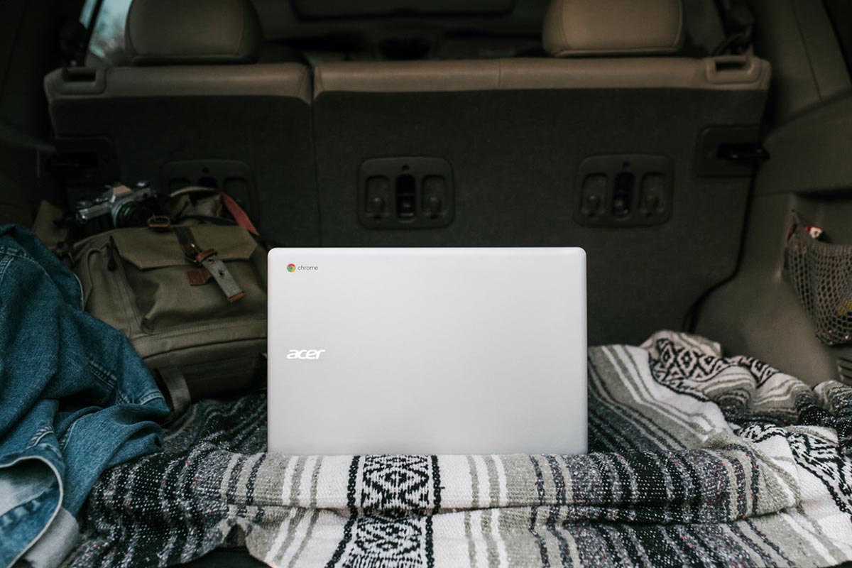Acer Chromebook placed on a blanket in the back of a car, representing traveling with computer devices
