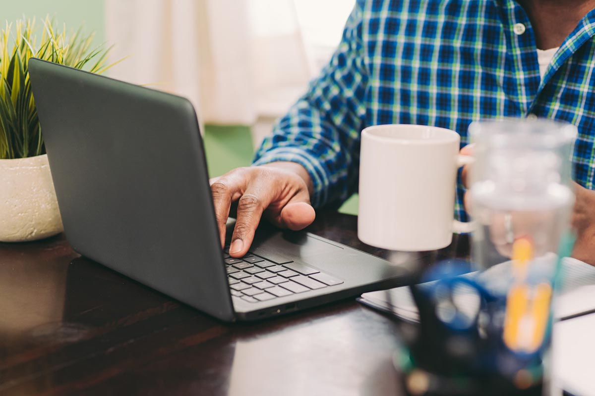 Person using an Acer laptop at a desk with a mug and office supplies, highlighting what to look for in refurbished computers